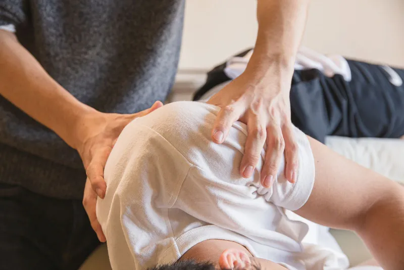Clinician performing hands-on treatment of a patient's leg